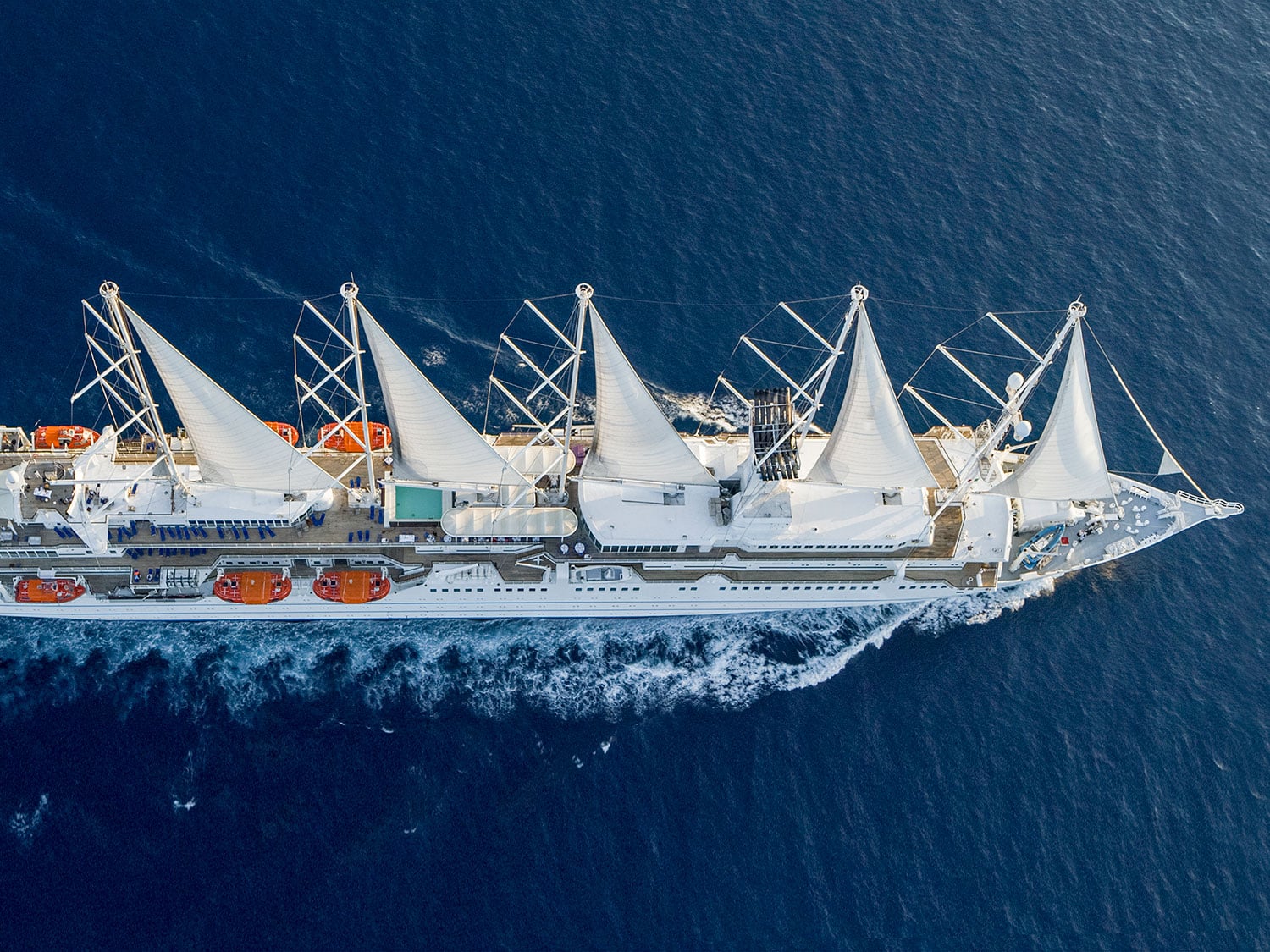 An aerial drone’s eye view of the Club Med 2 luxury sailing yacht on the open water.